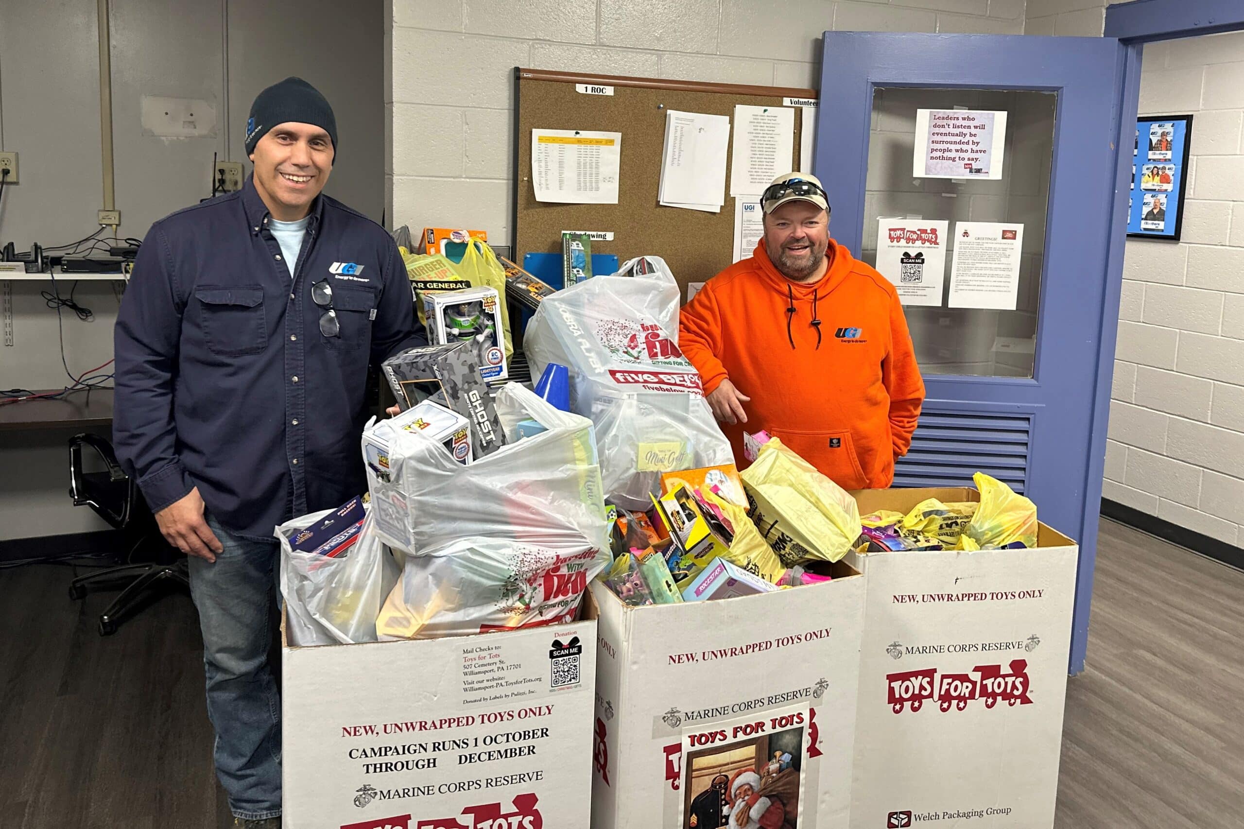 UGI employees posing for picture with large and overfilled Toys for Tots donation boxes