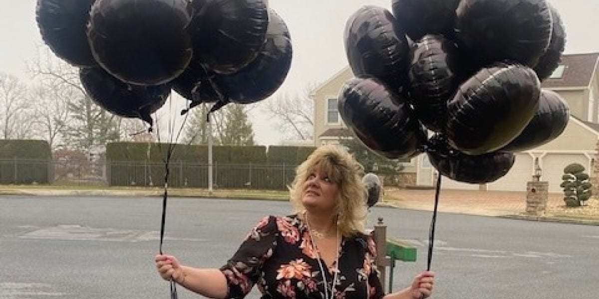 UGI employee Michele holds black balloons in memory of her son who lost his life to an overdose.