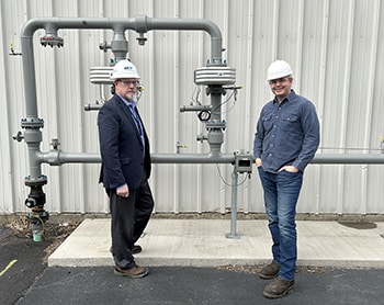 UGI employee and Lion employee outside brewery standing in front of gas meter and piping